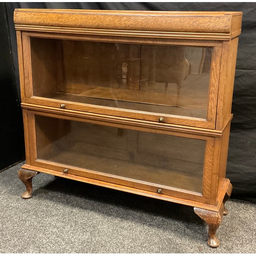 78 - An early to mid 20th century oak bookcase, by Meovoto, (similar to Globe Wernicke), two tiers of sta... 