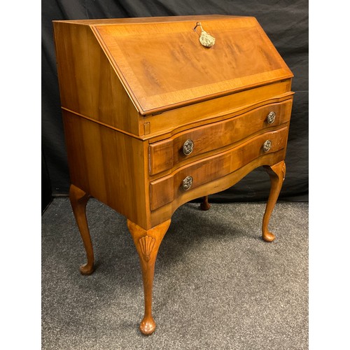 113 - A reproduction walnut bureau, serpentine shaped front, hinged fall door to top enclosing a fitted in... 