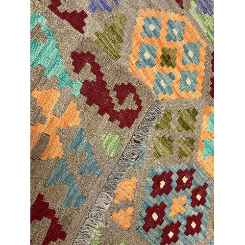 123 - A Turkish Anatolian Kilim rug, knotted with a geometric pattern in blue, orange, and burgundy, on a ... 