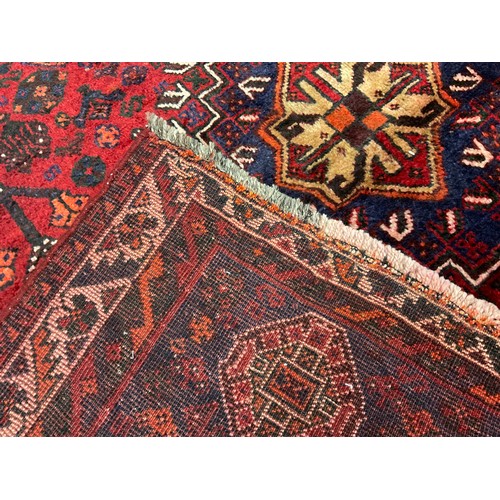 399 - A South West Persian Qashgai rug / carpet, hand-knotted with triple medallion in a field of stylised... 