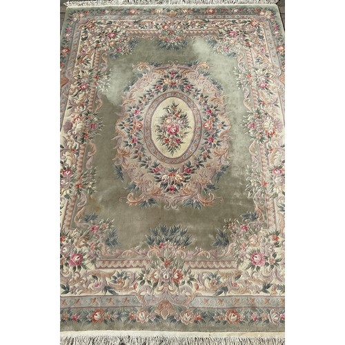 477 - A large Chinese woollen rug, with sculpted flower and foliage decoration, in tones of jade green, pi... 