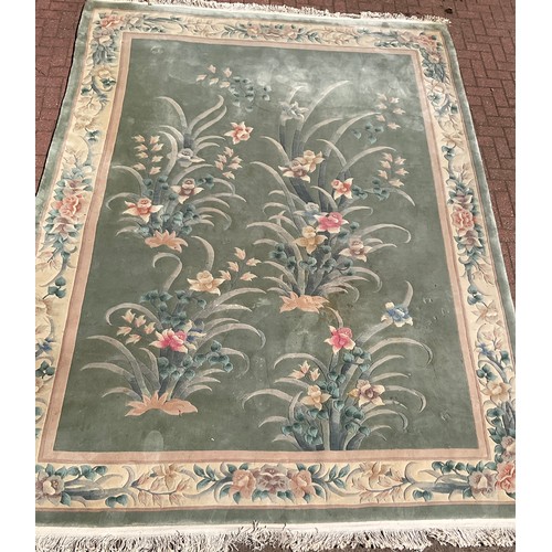 478 - A large Chinese woollen rug, decorated with sculpted scrolling foliage and flowers, in tones of beig... 