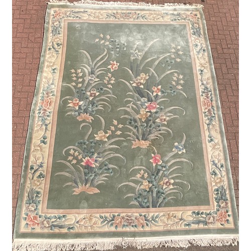 478 - A large Chinese woollen rug, decorated with sculpted scrolling foliage and flowers, in tones of beig... 