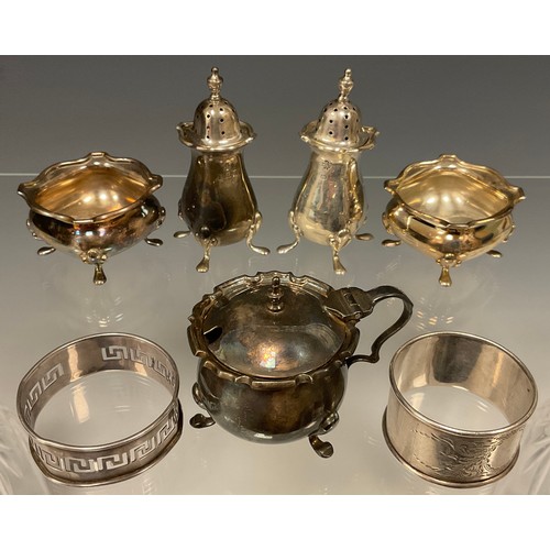 559 - A four piece silver condiment set, two pepperettes, two salts; a silver mustard; two silver napkin r... 