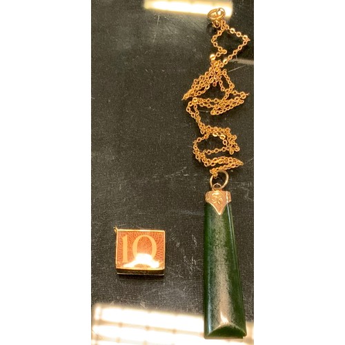 596 - A 9ct gold mounted jade table pendant necklace, 5.1g;  9ct gold 10 shilling note charm, 2.3 g gross