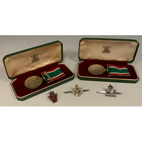 645 - Medals - Two Women's Voluntary Service Medals, one with long service bar, each cased;  similar pin b... 