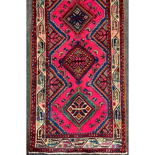 412 - A North west Persian Heriz runner carpet, hand-knotted with a central row of seven diamond form meda... 