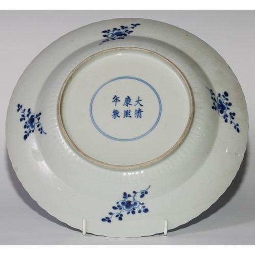 18 - A pair of Chinese shaped circular dishes, painted in tones of underglaze blue with flowers and scrol... 