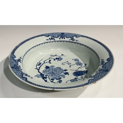 19 - An 18th century Chinese circular basin, painted in tones of underglaze blue with flowers and fruit, ... 