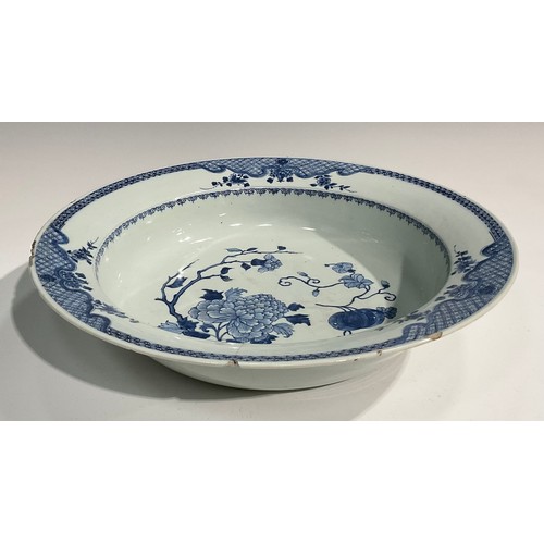 19 - An 18th century Chinese circular basin, painted in tones of underglaze blue with flowers and fruit, ... 