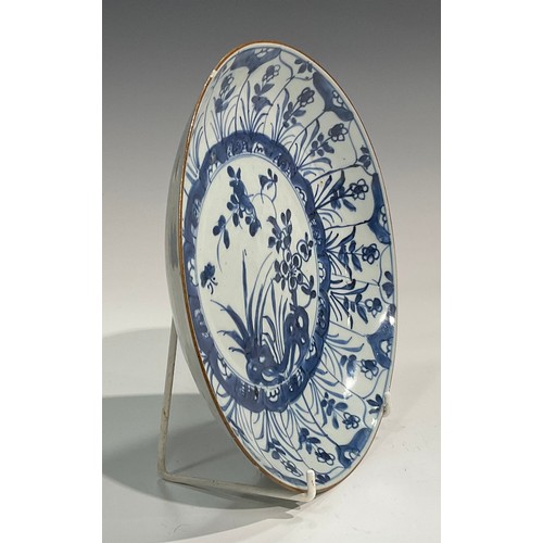 70 - A Chinese circular dish, painted in tones of underglaze blue with flowers and rock work, Kraak type ... 