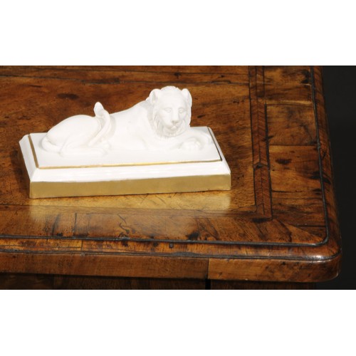 94 - A Dagoty porcelain model, of a recumbent lion, in the white with gilt borders, 11cm wide, red mark, ... 