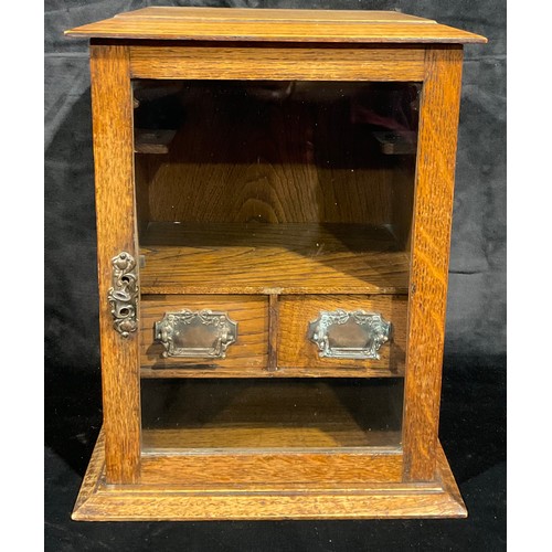 29 - An Edwardian oak smoker's cabinet, glazed door, fitted with two drawers, key