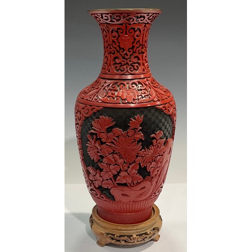 31 - A Chinese cinnabar lacquer type baluster vase, decorated with peonies within a fretwork trellis, blu... 