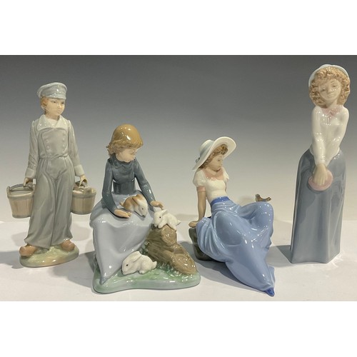 36 - A Nao Lladro figural group of a young girl perched upon logs beside Rabbits, 18cm high; other Nao Ll... 