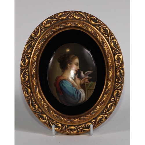 69 - A 19th century Continental porcelain oval plaque, painted in polychrome with a young girl and a dove... 