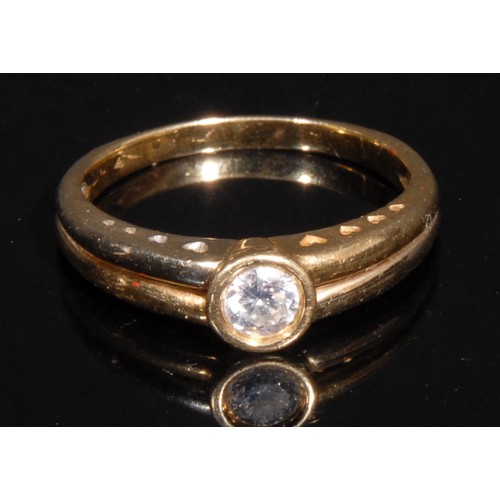 971 - A diamond and 18ct gold solitaire ring, the brilliant cut stone bezel set, divided shank, the should... 