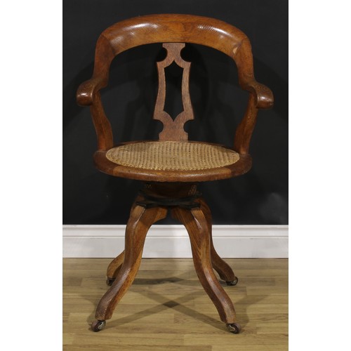104 - A late Victorian/Edwardian oak swivel desk chair, 90.5cm high, 61cm wide, the seat 42cm wide and 40c... 