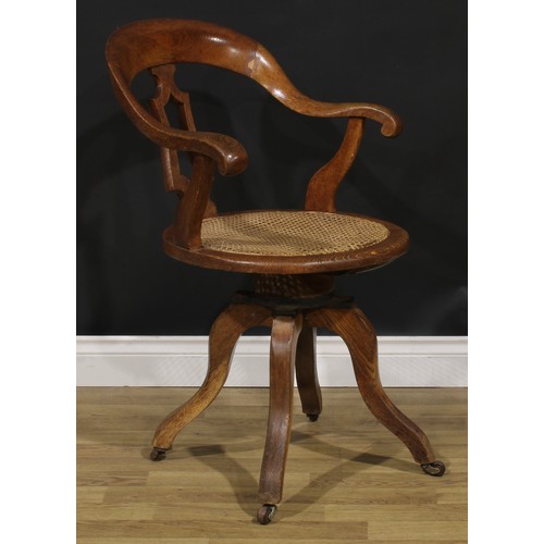 104 - A late Victorian/Edwardian oak swivel desk chair, 90.5cm high, 61cm wide, the seat 42cm wide and 40c... 