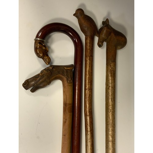 957 - Walking sticks - two folk art walking sticks, bird and horses head terminals; others, one carved wit... 