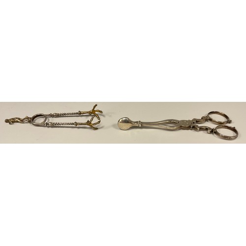 32 - A pair of Georgian silver scissor action sugar nips, marks worn, London, c.1755;  a pair claw nips (... 