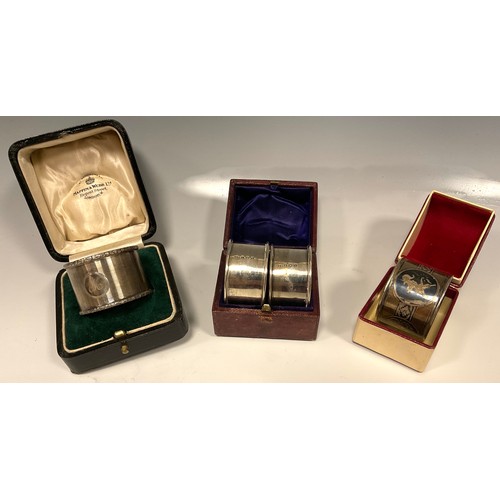 33 - A pair of silver napkin rings, E Edmonds, Birmingham 1917, cased;  another wavy banded, Mappin & Web... 