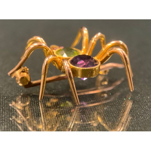 123 - A spider brooch, amethyst and peridot green body, pink cabochon eyes, unmarked gold coloured metal m... 