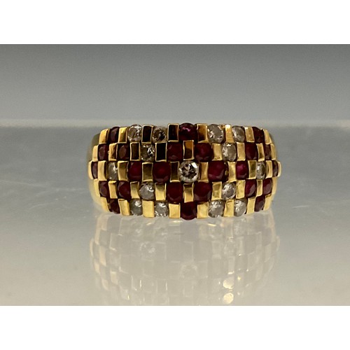 99 - A diamond and ruby chequer panel ring, set with fifteen round brilliant cut diamonds and twenty four... 