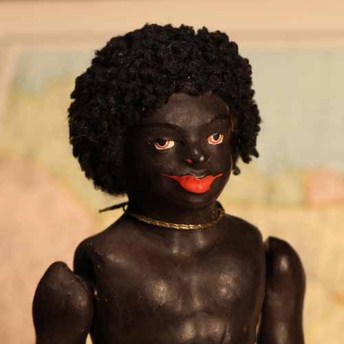 4045 - An early 20th century black composition jointed doll, painted features, black flock type hair, 20cm ... 
