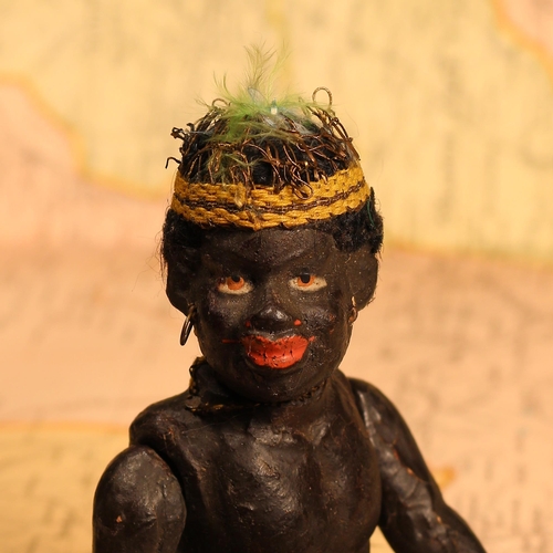 4049 - An early 20th century black composition jointed doll, painted features, black flock type hair, 15cm ... 