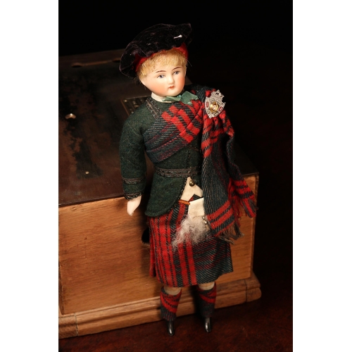 4081 - A bisque head and partially stuffed cloth bodied costume doll, the bisque head with painted features... 