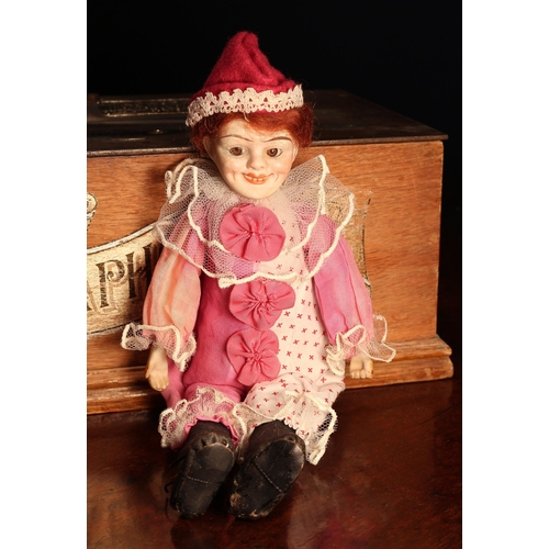 4096 - A German bisque head and partially stuffed cloth bodied doll, as a novelty Jester, the bisque head i... 