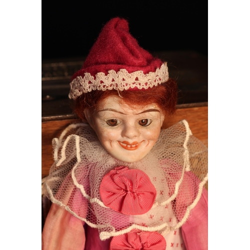 4096 - A German bisque head and partially stuffed cloth bodied doll, as a novelty Jester, the bisque head i... 