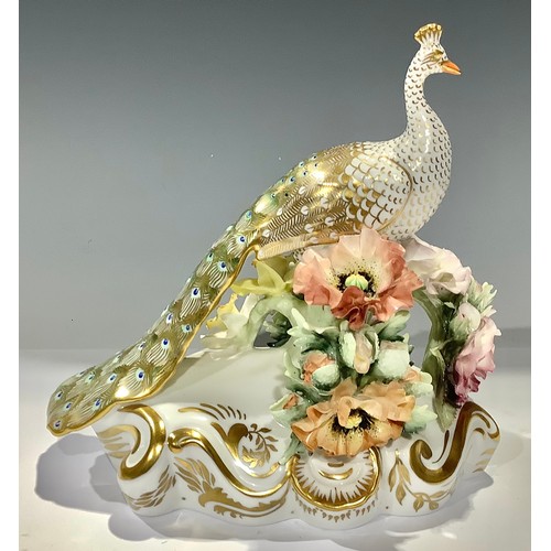 2 - A Royal Crown Derby Peacock, perched upon a bough encrusted with flowers, scroll base, printed mark ... 