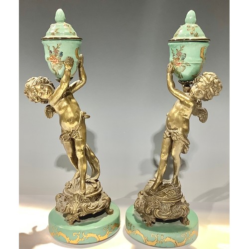 9 - A pair of Italian gilt bronze figural garnitures, each modelled as a boy holding aloft an enamelled ... 