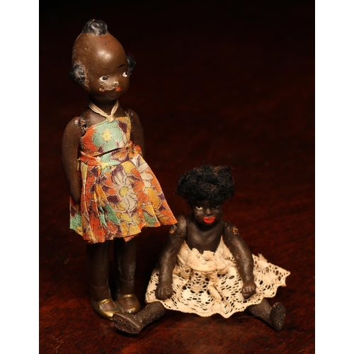 4112 - An early 20th century black composition jointed doll, painted features, black flock type hair, 9cm h... 