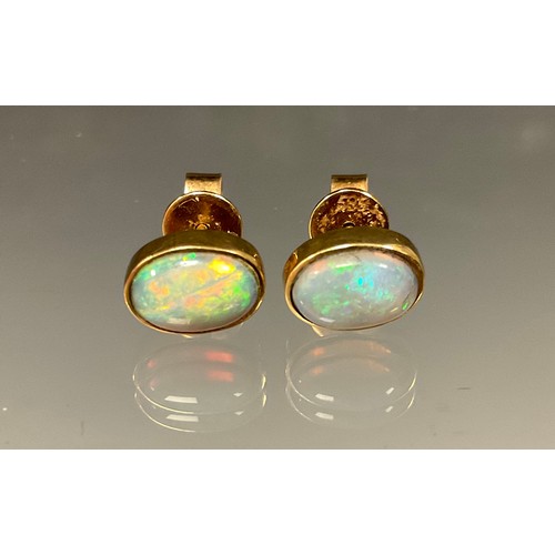 460 - A pair of opal cabochon earrings, flashing green, blue, orange and red colour play, yellow metal mou... 