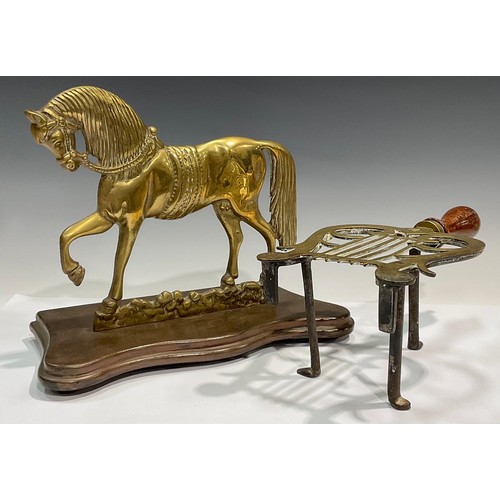 92 - A Victorian brass hearth stand, modelled as a horse; a lyre shaped trivet (2)