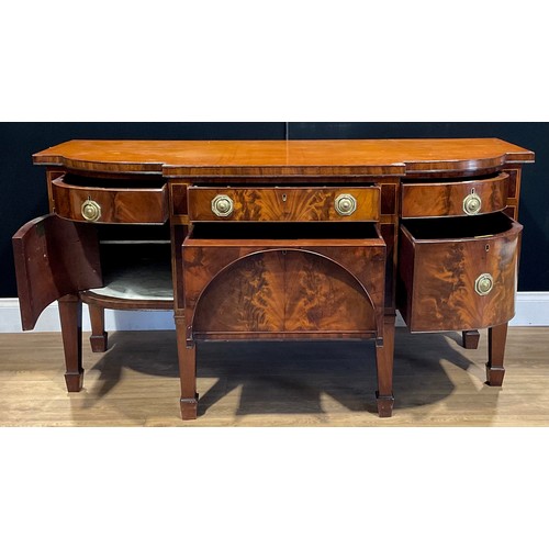 105 - A George III mahogany serving table or sideboard, slightly oversailing top above an arrangement of d... 