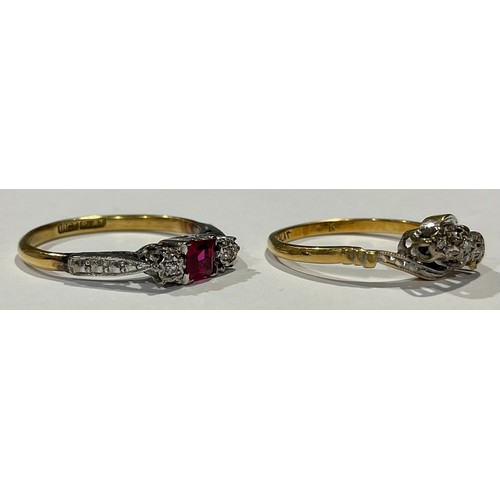 570 - An 18ct gold ring, the platinum bezel set with a central princess cut ruby, flanked by a pair of ill... 