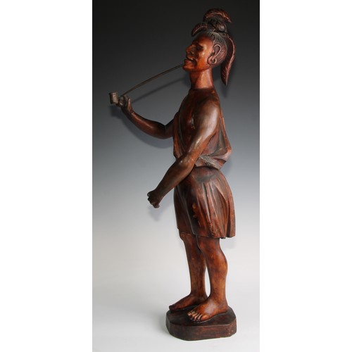 34 - A 19th century carved tobacconists advertising figure as a native American, standing wearing feather... 