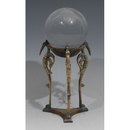 629 - Mysticism and the Occult - a crystal ball, the tripod stand cast with stylised avian brackets, 20.5c... 