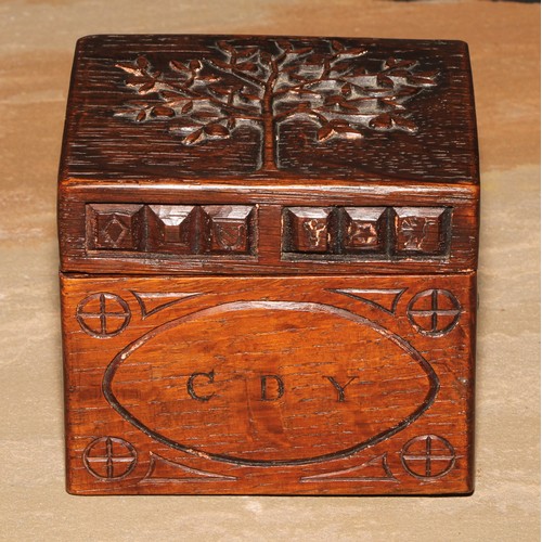 440 - An Arts and Crafts oak rectangular box or caddy, the hinged cover carved with a stylised apple tree,... 