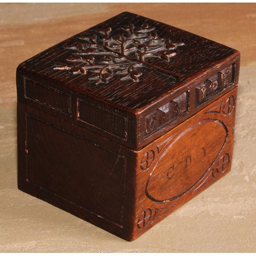 440 - An Arts and Crafts oak rectangular box or caddy, the hinged cover carved with a stylised apple tree,... 