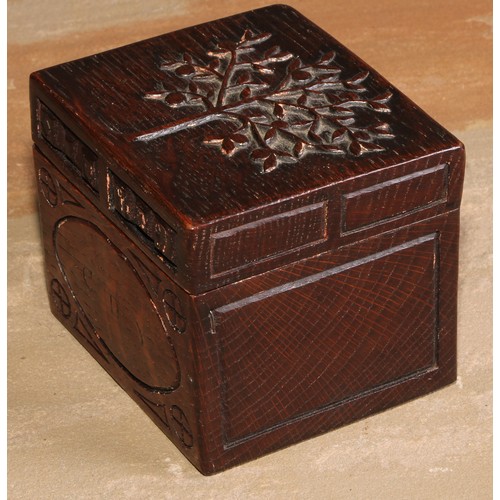 440 - An Arts and Crafts oak rectangular box or caddy, the hinged cover carved with a stylised apple tree,... 