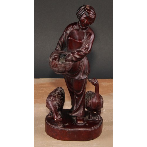 321 - A pair of Chinese hardwood figures, carved as a young fisherman and a girl feeding geese, 25.5cm and... 