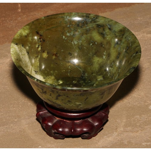 179 - A Chinese spinach jade bowl, 10cm diam, hardwood stand