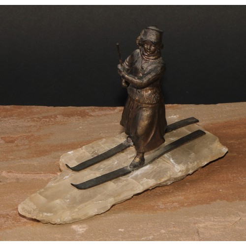 529 - Continental School (early 20th century), a spelter figure, of a lady skiing, faux ice base, 18cm lon... 