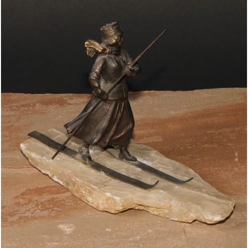 529 - Continental School (early 20th century), a spelter figure, of a lady skiing, faux ice base, 18cm lon... 