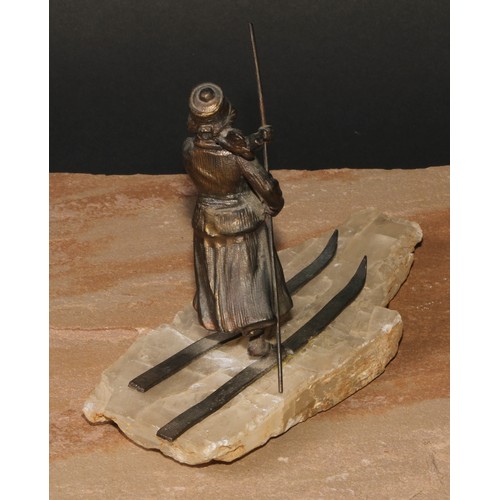 529 - Continental School (early 20th century), a spelter figure, of a lady skiing, faux ice base, 18cm lon... 